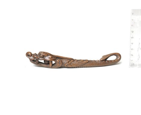 A wood sashi netsuke of a hiryu (flying dragon)18th centuryThe limbless beast looking forward, its large head with double-inl