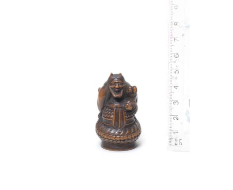 A boxwood netsuke of KiyohimeLate 18th/early 19th centuryThe witch partially manifesting as a dragon, holding a bell mallet, 