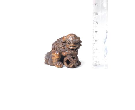 A wood netsuke of a shishiBy Suketada, Takayama, Hida Province, late 19th centuryThe shishi seated, its head turning to the r