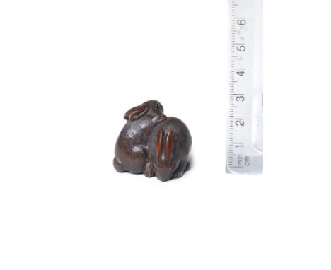 A wood netsuke of two rabbitsBy Kokei, Kuwana, Ise Province, 19th centuryOne rabbit seated, bending forward nibbling at morse