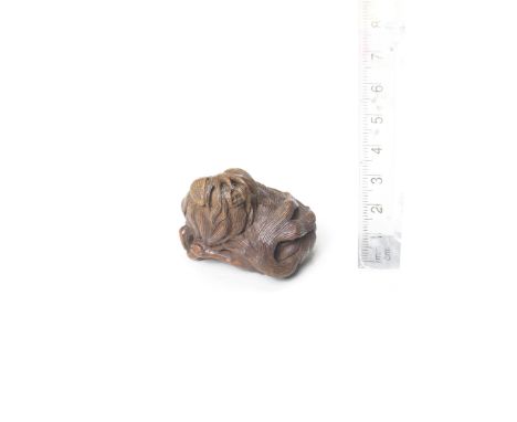 A boxwood netsuke of a Chin dogBy Tametaka, Nagoya, early 19th centuryThe dog lying down, its head turned to the left with a 