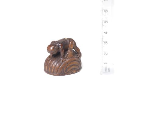 A wood netsuke of Shoki and oniBy Tomokazu, Gifu, early/mid-19th centuryThe oni crawling on a basket, trapping Shoki inside, 