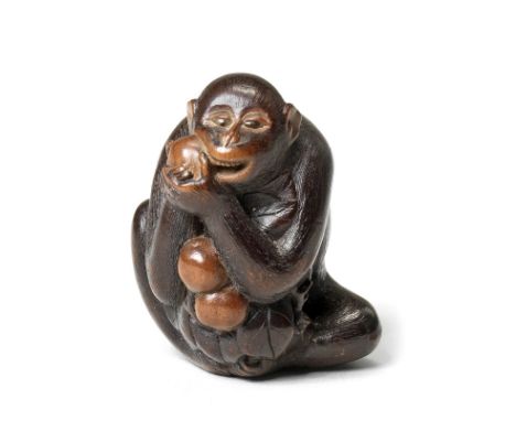 A wood netsuke of a monkeyBy Masakazu, Gifu, 19th centuryThe monkey seated, vigorously gnawing at a persimmon held at the rig
