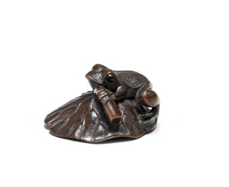A wood netsuke of a toad on a lotus leafEarly/mid-19th centuryThe toad seated on the overturned large leaf and gripping the t