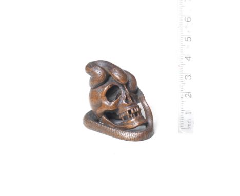 A boxwood netsuke of a snake and skullBy Kawakata Masanori, late 19th centuryThe human skull realistically rendered, the snak