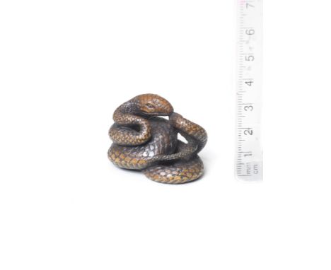 A boxwood netsuke of a coiled snakeBy Nobumitsu, 19th centuryThe snake coiled in several irregular loops, its head resting at