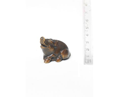 A boxwood netsuke of a boarBy Nanboku, mid-19th centuryThe seated boar raising its head, its legs tucked under its body to fo
