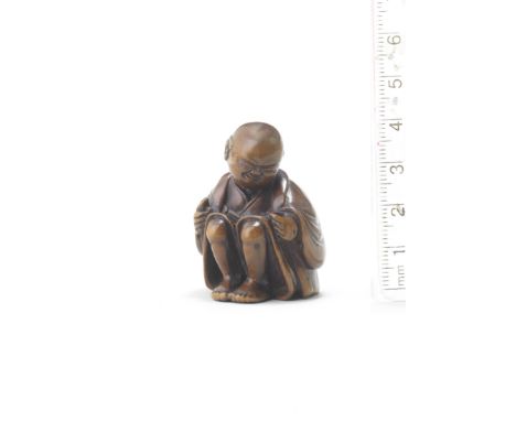A wood netsuke of a man applying moxaAttributed to Miwa, late 18th/early 19th centuryThe man seated, his face contorting in p
