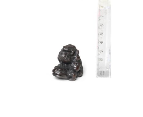 A wood netsuke of Gama SenninBy Hokyudo Itsumin, Edo, mid-19th centuryGama Sennin seated on a huge toad, his head turned to t