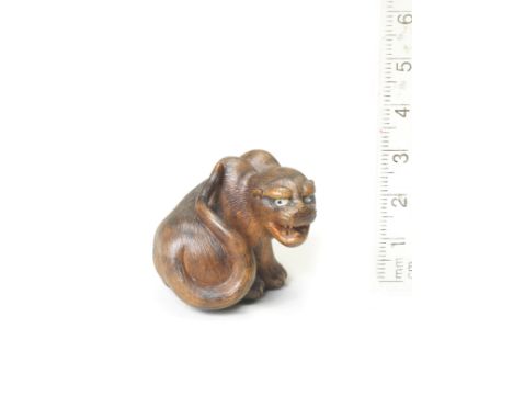 A wood netsuke of a seated tigerBy Hakuryu II, Kyoto, 19th centurySeated with its head turned to the right, its tail passing 