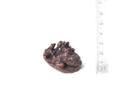 A wood netsuke of frogs and a toad on a lotus leafBy Seimin, 19th centuryThe toad and smooth-skinned frog locked in combat on