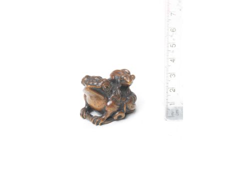 A wood netsuke of a toad and youngBy Miwa, Edo, early 19th centuryThe adult toad grasping a worm in its forelimbs, its smooth