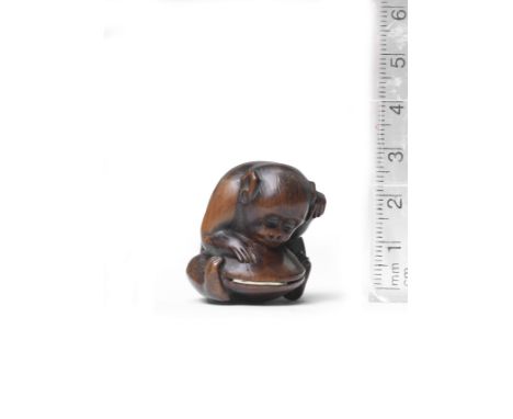 A wood netsuke of a monkey and clamBy Koichi, 19th centuryThe monkey seated, leaning forward with an intent expression, its f