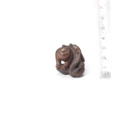 A wood netsuke of a tiger and dragonBy Masatsugu, late 19th centuryThe tiger seated on the dragon's twisting body, its head r