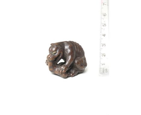A wood netsuke of a wolfBy Tanaka Minko (1735-1816), Tsu, Ise Province, late 18th centuryThe wolf seated and leaning forward,