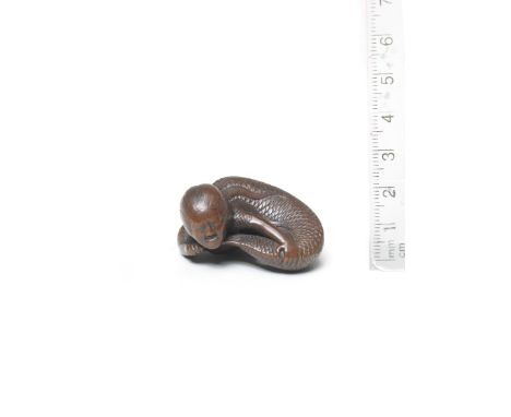 A wood netsuke of a mermaidBy Tadatoshi, Nagoya, early 19th centuryThe mermaid lying, turning to her left, curling up as she 