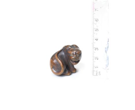 A wood netsuke of a seated tigerBy Hakuryu II, 19th centuryThe tiger seated, its head turned to the right snarling, its long 