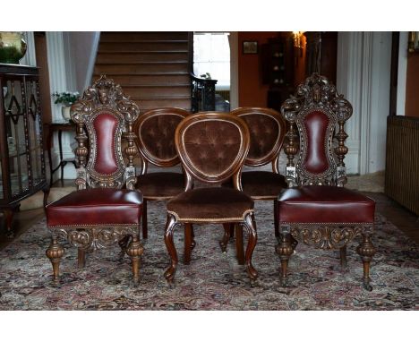 A pair of Victorian carved oak side chairs in elaborate “Jacobethan” style, the scroll pierced tops centred by carved masks (