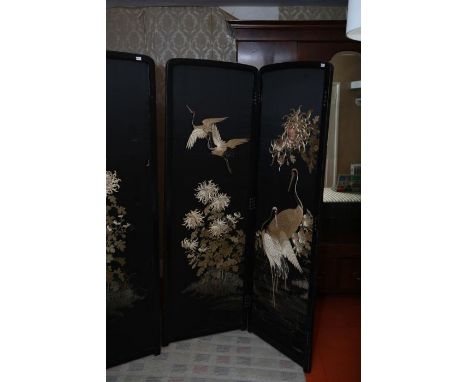 A Japanese four-fold embroidered room screen, late Meiji Period circa 1885-1890, worked with cranes and profusions of chrysan