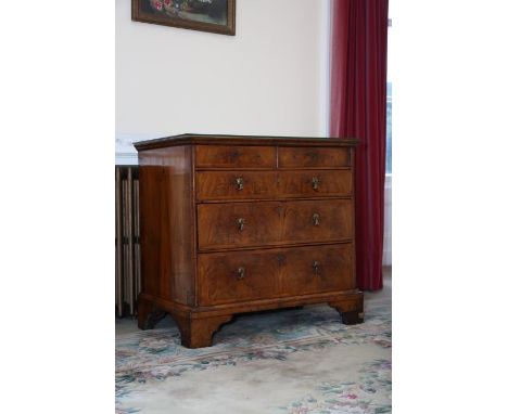 An early 18th century English figured walnut chest of drawers, the top quarter veneered, double feather-strung and broadly cr
