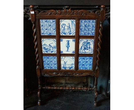A 1920’s oak fire screen inset with nine Dutch 18th/19th century blue and white tiles, 88cm high   Cond: one tile cracked.OBJ