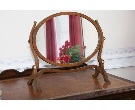 A Georgian style mahogany oval swing mirror, on slender S uprights, bone bosses, 60cm wide   OBJECT LOCATION: MAIN BEDROOM 