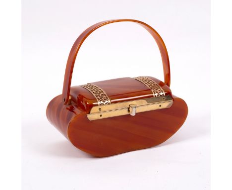 A 1940s bakelite handbag, casket shaped with gilt metal mounts, the hinged lid with interior mirror and with swing handle, 22