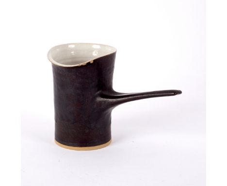 Lucie Rie (1902-1995), a milk jug, with manganese glaze and cream interior, elongated handle, impressed mark, 10cm high (rim 