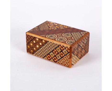 A Japanese twenty step puzzle box, decorated intricate patterns and designs, with instruction leaflet, 11.5cm x 8cm CONDITION
