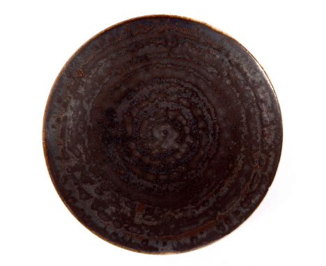 Lucie Rie (1902-1995), a small plate, manganese glaze, spiral patterning and cream reverse, impressed mark, 13cm diameter CON