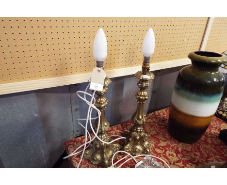 A pair of heavy brass moulded candle stick lamps