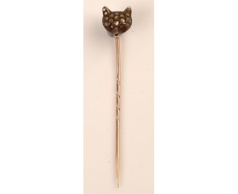 A Victorian fox mask stick pin, pave set with rose-cut diamonds and ruby cabochon eyes, in yellow metal mount, 6cms high.