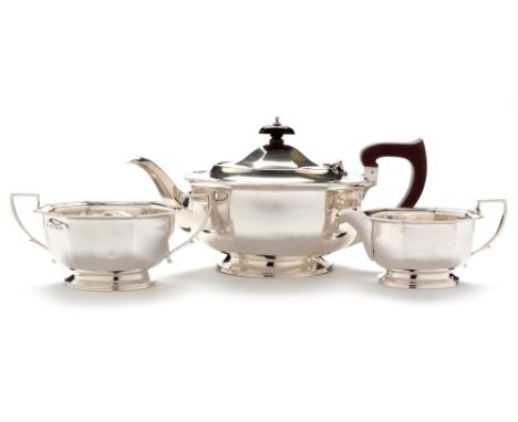 A George V three piece silver tea service, by Addie Brothers, Birmingham 1935, of octagonal form, the teapot with stained woo