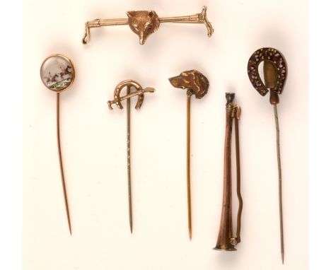 Late 19th/early 20th Century stick pins, comprising: intaglio hunting pin; garnet set horseshoe; dog's head; hunting horn; an