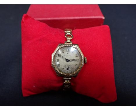 ROLEX: A LADY'S 9CT GOLD WRISTWATCHwith manual wind movement, the silver dial with subsidiary seconds dial, black Arabic nume