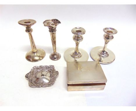 A PAIR OF LOADED SILVER DESK CANDLESTICKS a single example; a silver cigarette box; two silver napkin rings; a silver ring tr