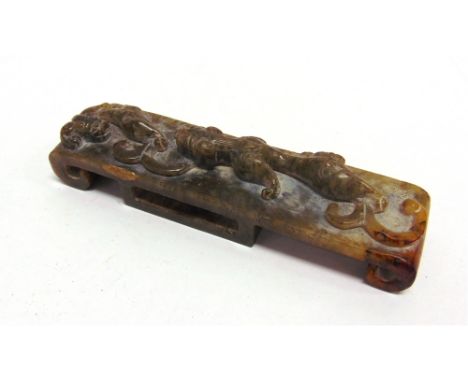 A CHINESE JADE CEREMONIAL SWORD HILT with carved decoration of pair of creatures, 13cm long