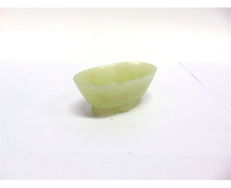A SMALL CARVED JADE OVAL BOWL  supported on four scroll feet, possibly a brush washer, 8cm wide