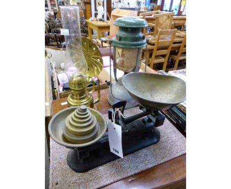 A set of cast iron kitchen scales with nested set of brass weights together with two oil lamps. (3)