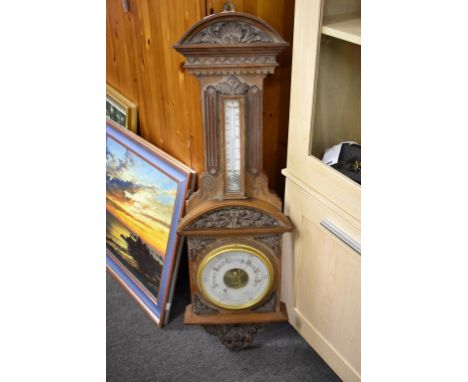 A Victorian carved walnut aneroid barometer