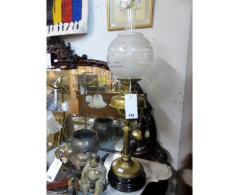 A vintage brass oil lamp with glass globe.