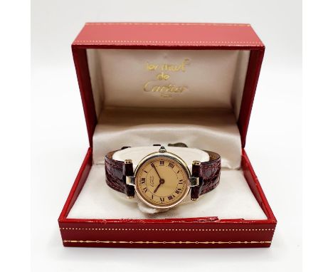 A ladies silver gilt Les Must de Cartier quartz wristwatch, with Roman numerals, and a cabochon sapphire winding button, boxe