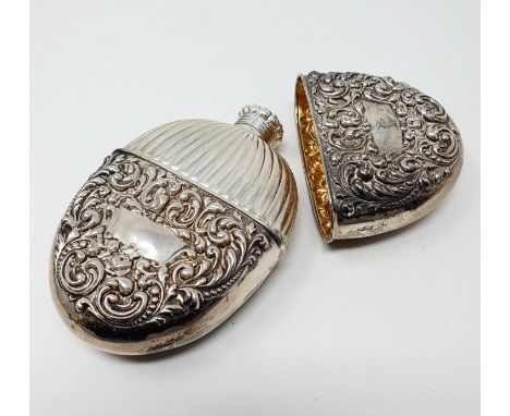 A Sterling silver flask and cup, of oval form, embossed scrolling foliage, 2.6 ozt, 12 cm high 