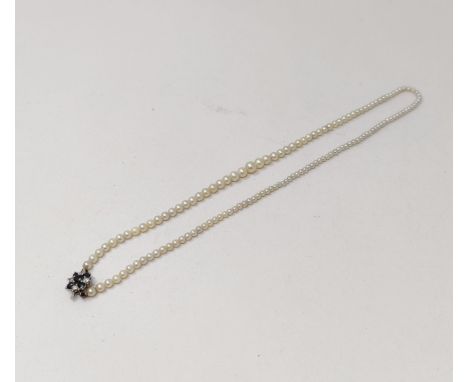 A cultured pearl necklace, with a diamond and sapphire clasp 