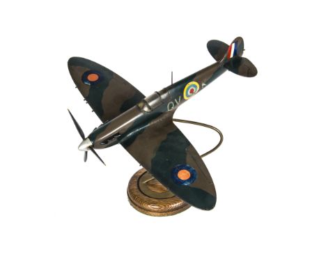 A Spitfire Desk Ornament, 1950s painted wooden model of QV K Mk1 Spitfire on brass support, with circular oak plinth, some we