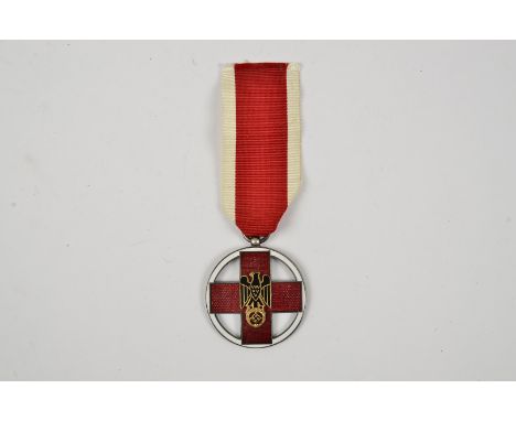 A DRK Service medal, the German Red Cross medal with red and white enamel decoration, with applied eagle and Swastika motif, 