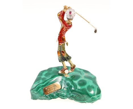 18ct gold and enamelled model of a golfer poised at the top of his swing, his bonnet set with ruby and diamonds, the golf bal