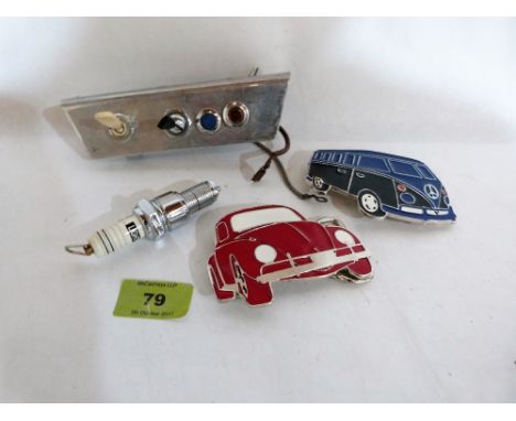 A 1960's switch panel, a spark plug key ring and two VW enamel badges