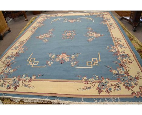 A large 20th Century light blue and cream ground wool floor rug with floral spray decoration