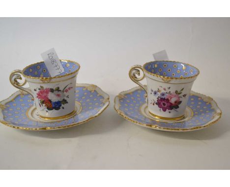 A pair of early 19th Century English porcelain cups and saucers with floral designs